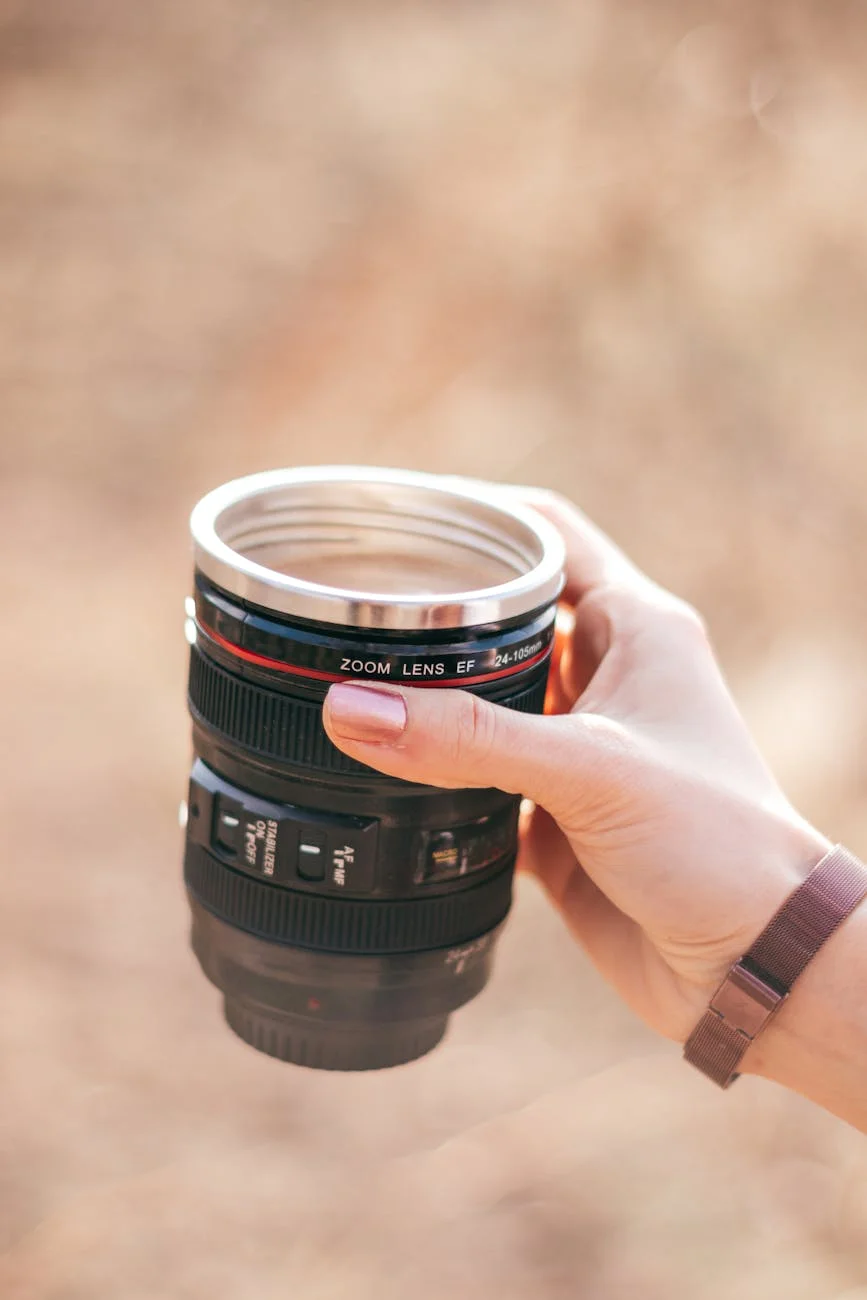 A Hand Holding A Camera Lens Shaped Mug 1