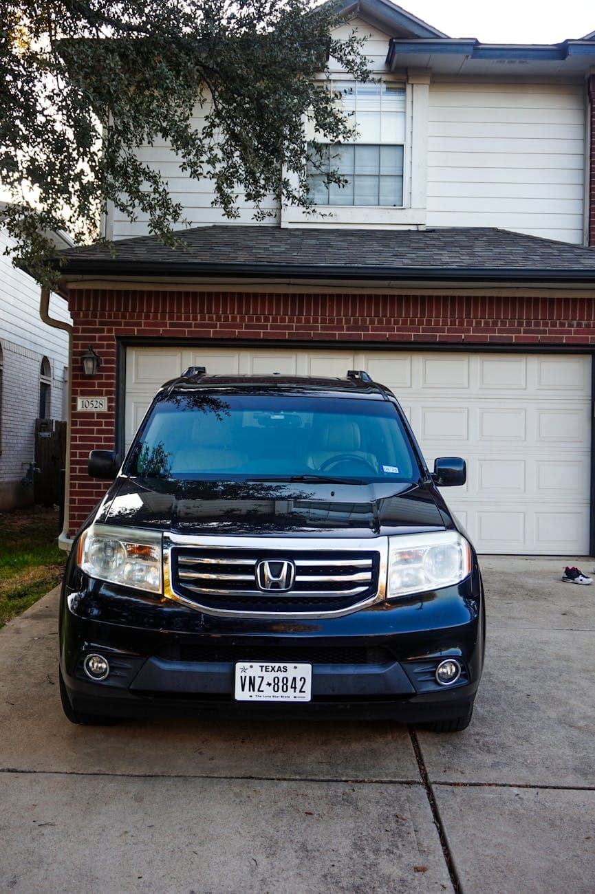 A Black Suv Parked In Front Of A Suburba 3