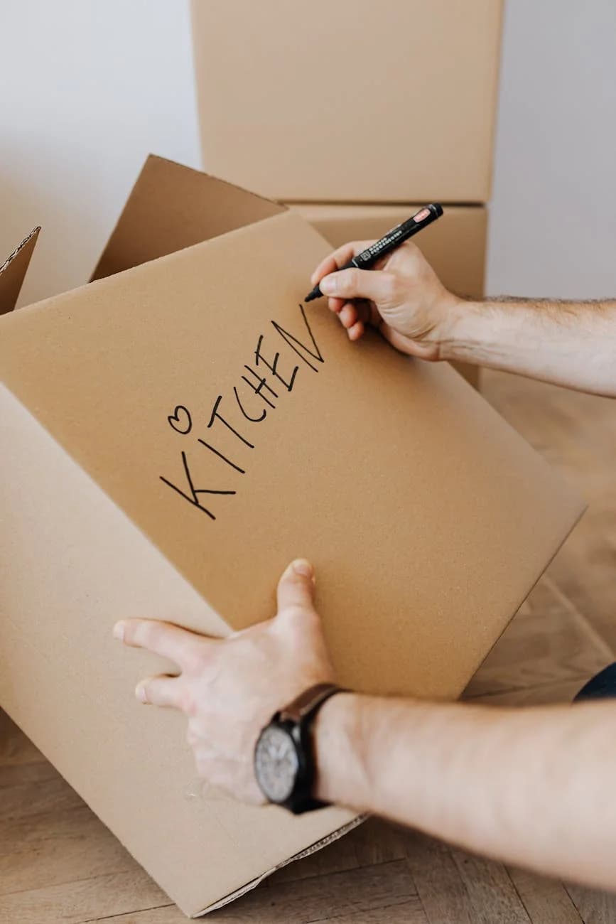A Man Labels A Cardboard Box Kitchen Dur 1
