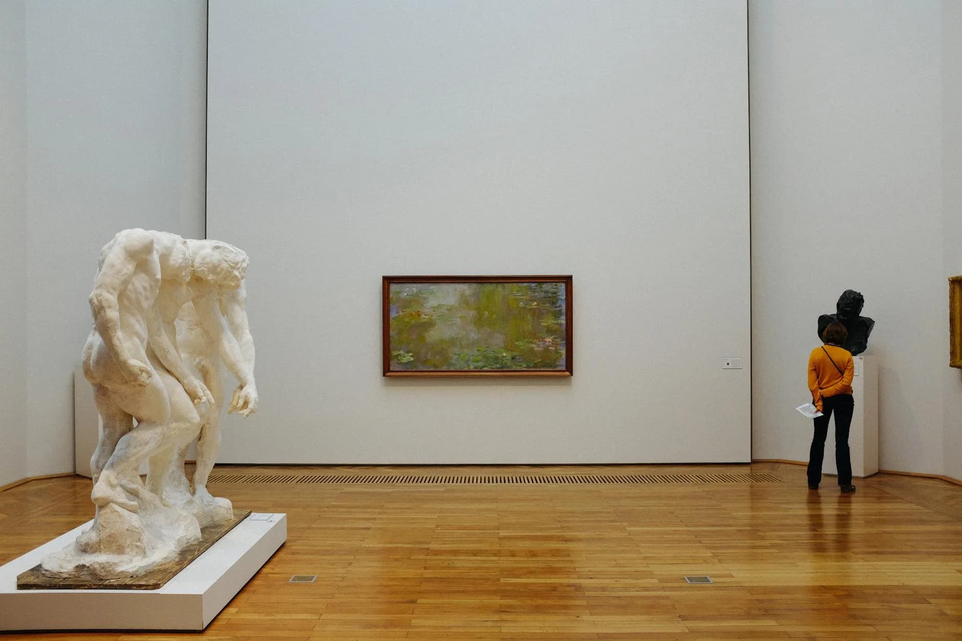 A Visitor Examines Sculptures And Painti 2