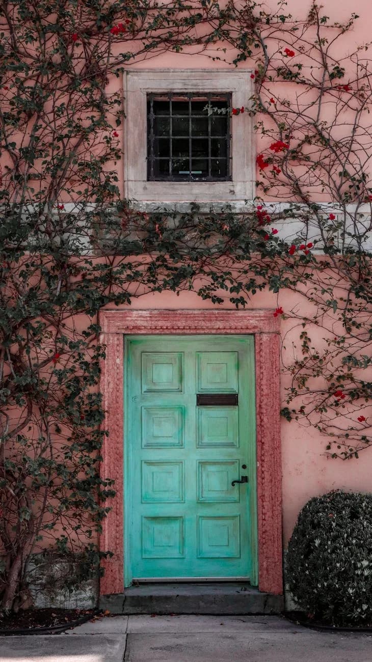 A Vibrant Teal Door Set Against A Coral 2
