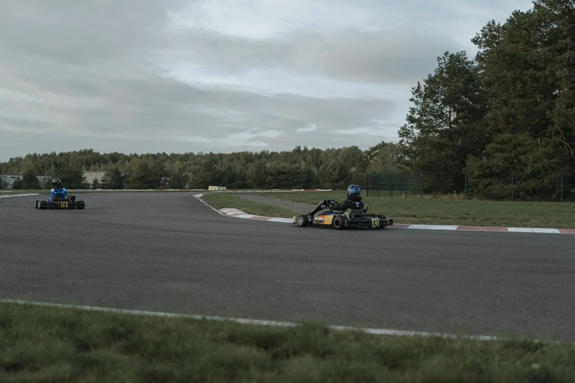 Two Go Karts Race On An Outdoor Track Su 1