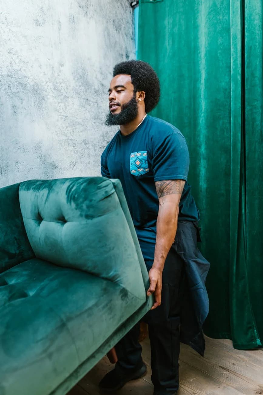 Bearded Man Carrying A Teal Velvet Couch 3