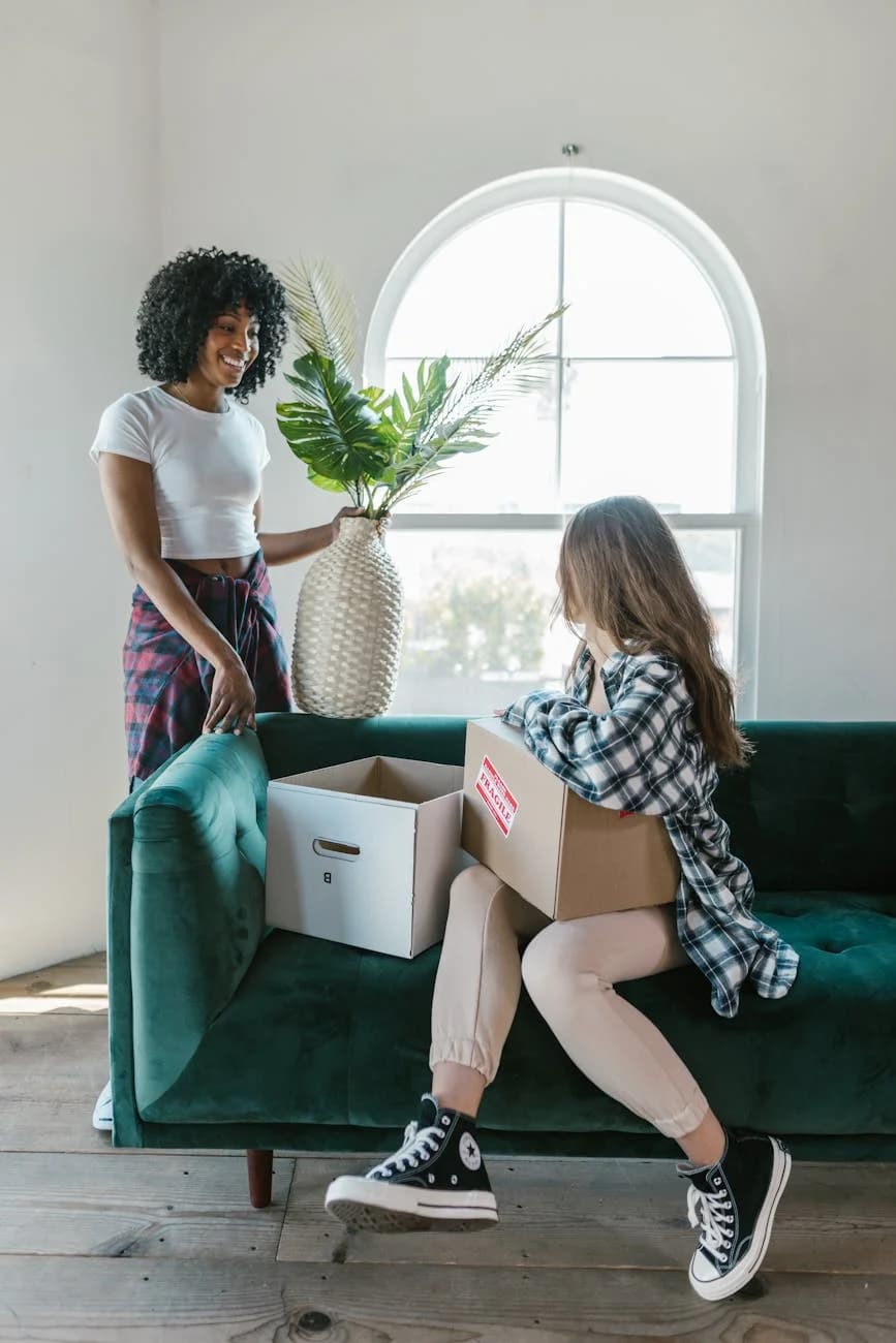 Two Young Women Unpack Moving Boxes In T 2