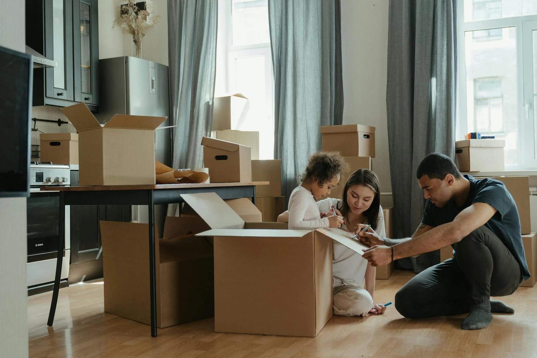 A Family Unpacks Moving Boxes In Their N 1
