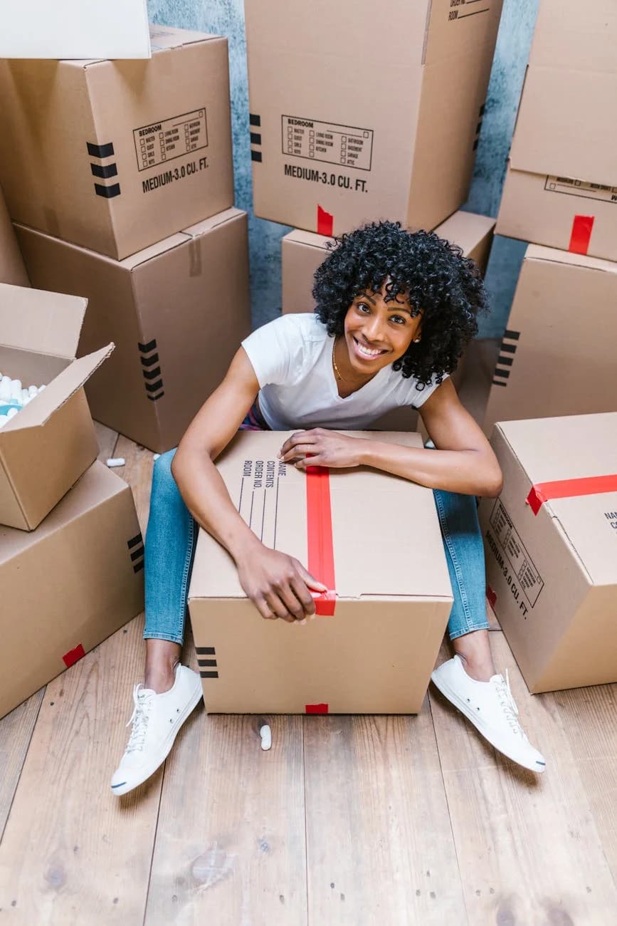 Happy Woman Sitting Among Boxes While Pa 4
