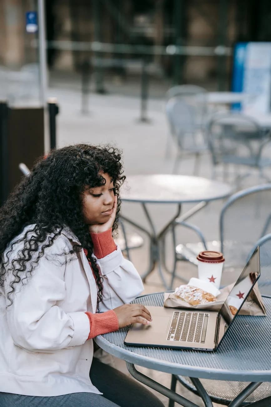 A Thoughtful Woman Using A Laptop At An 3