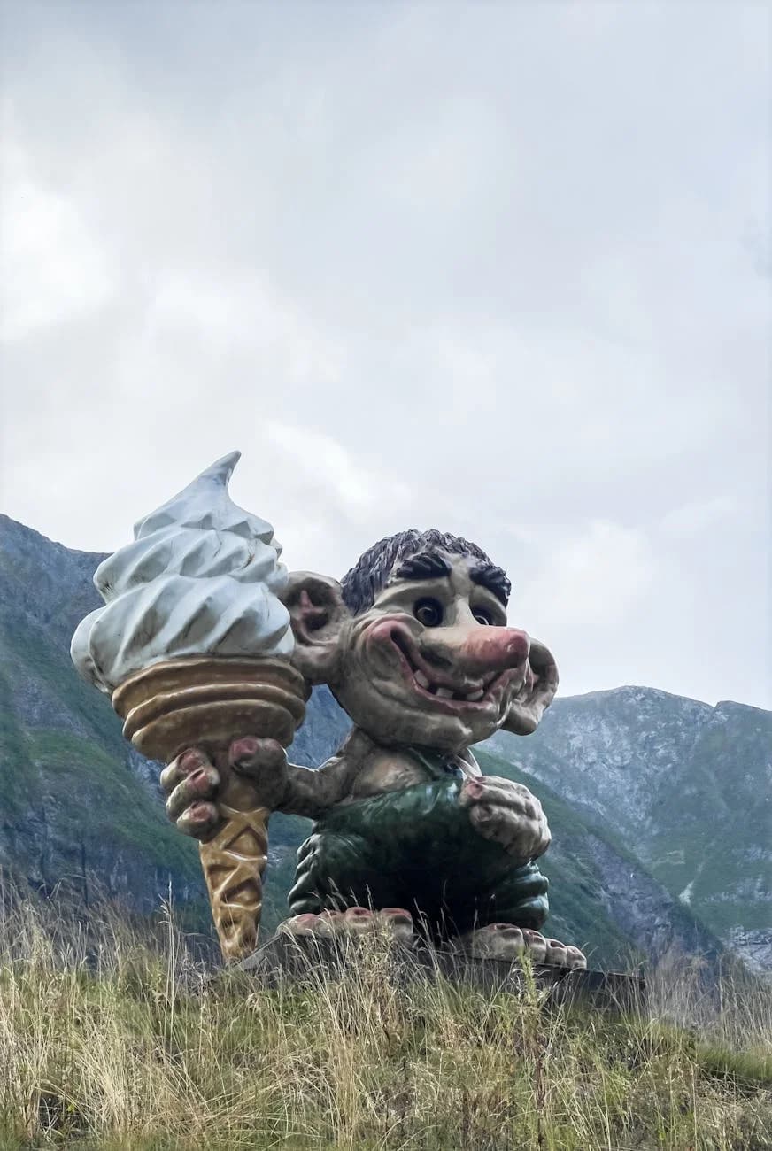 A Playful Troll Sculpture Holding Ice Cr 1