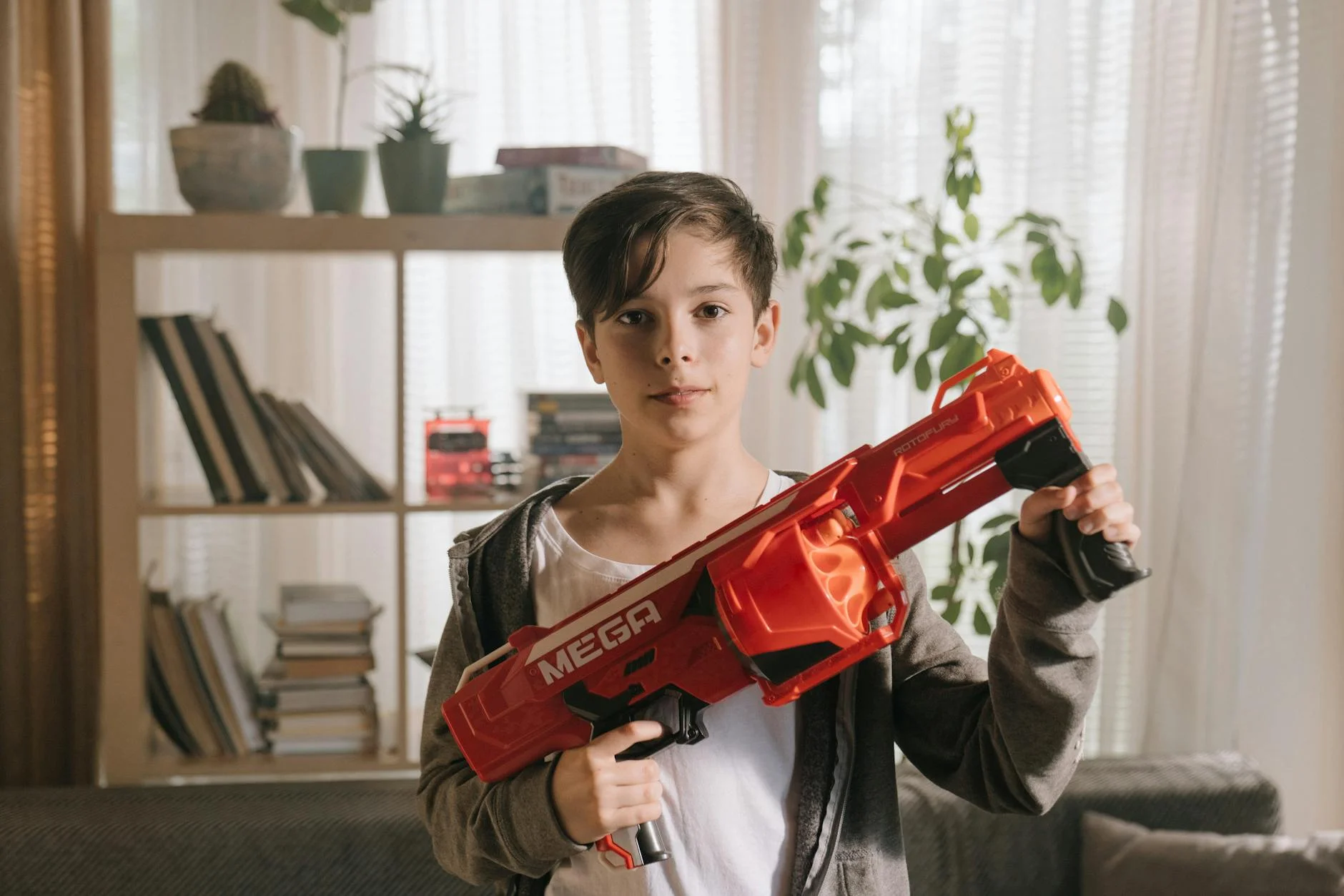A Young Boy Poses Indoors Holding A Larg 4