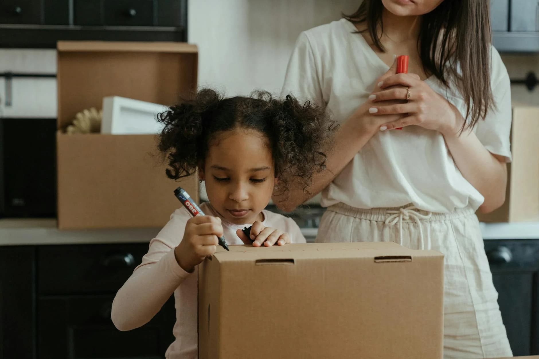 A Mother And Her Daughter Pack Boxes Whi 1