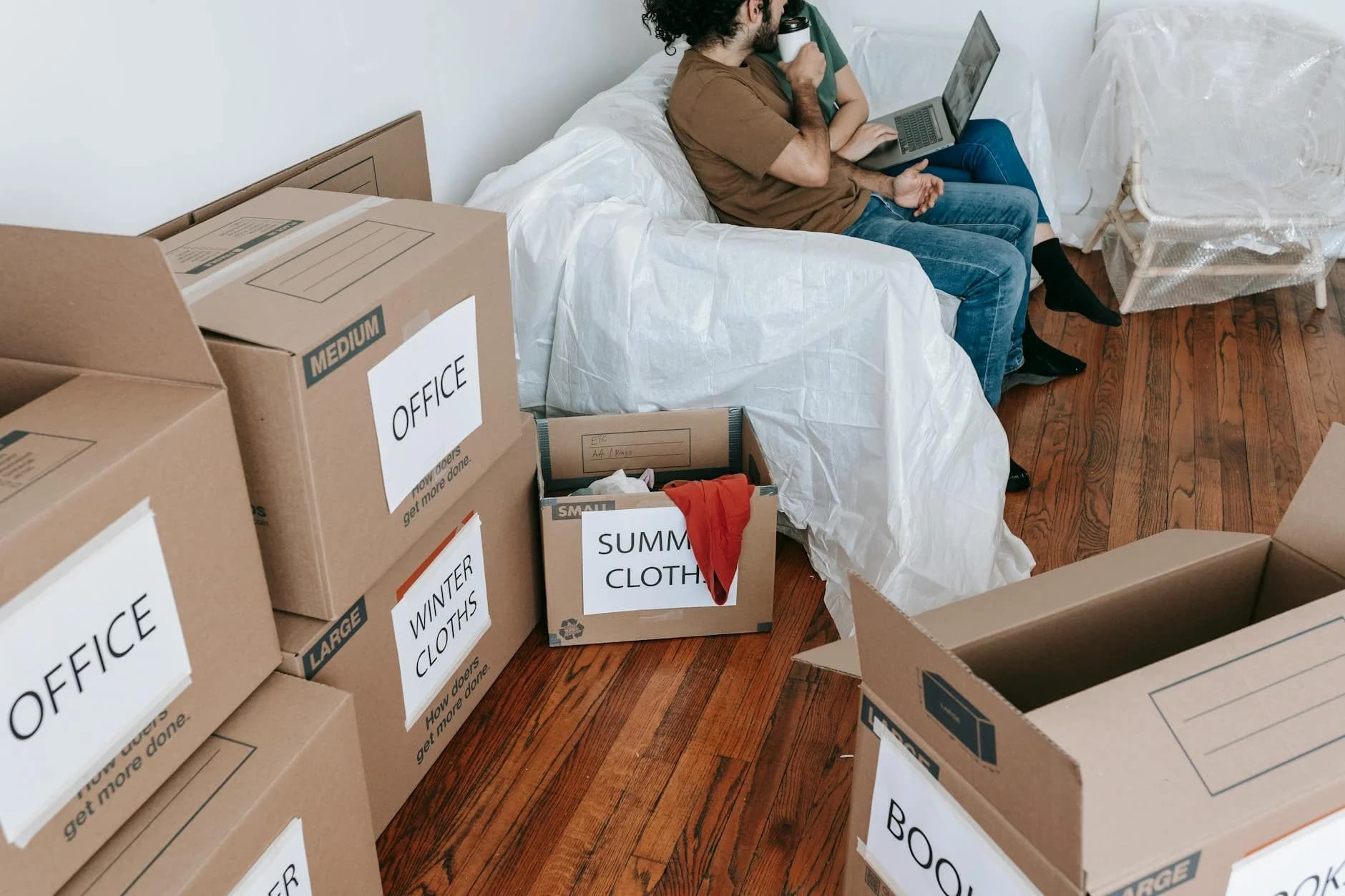 A Couple Seated On A Couch Surrounded By 3