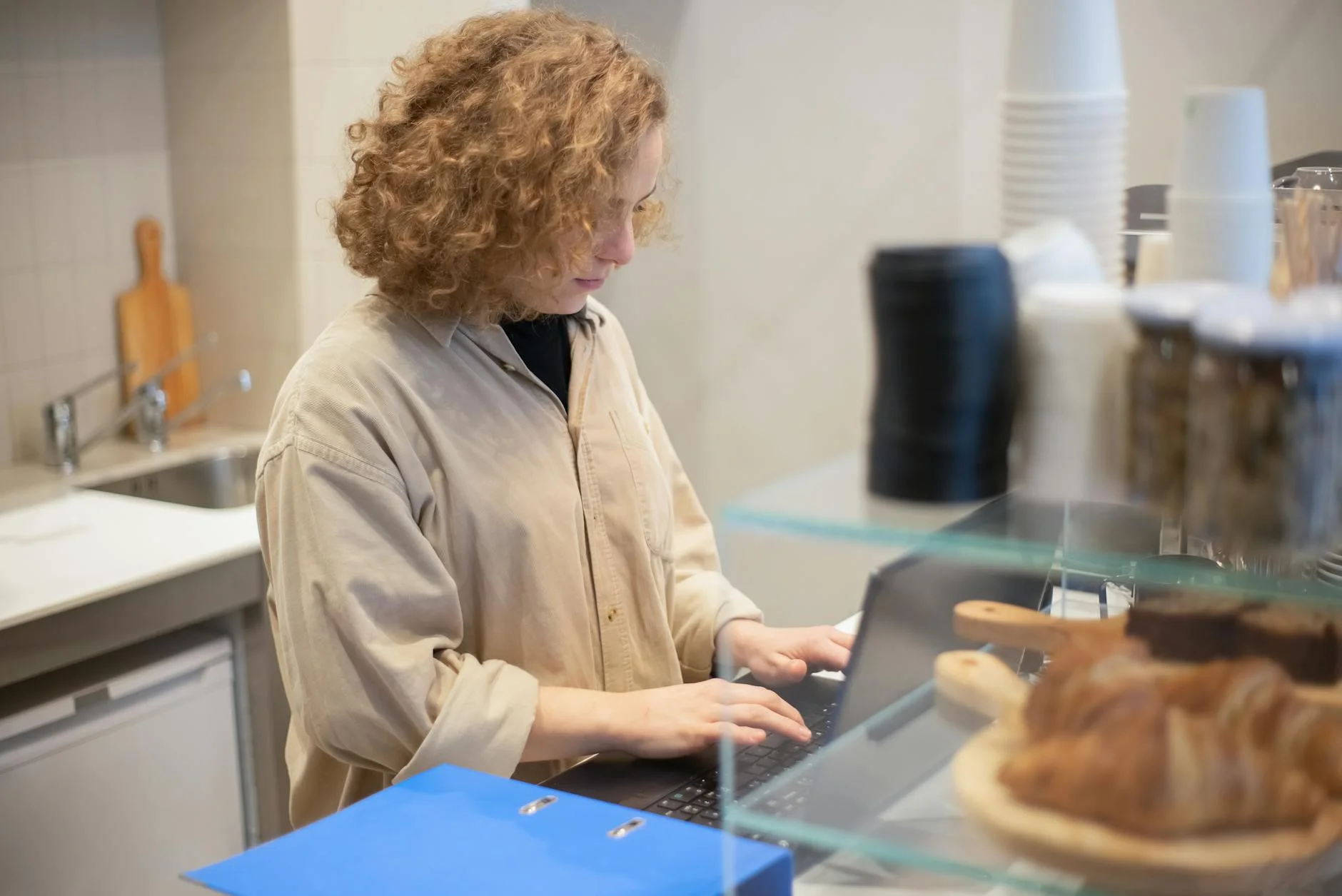 A Young Woman Uses A Laptop Behind A Caf 1