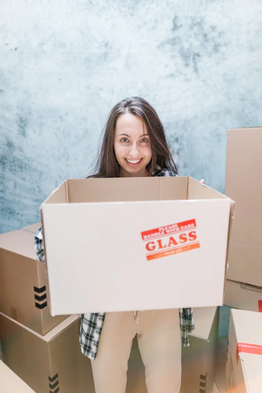 Smiling Woman Holding A Box Marked Fragi 3