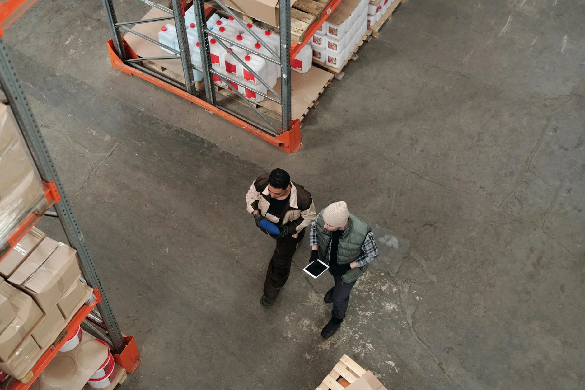 Two Workers Discussing Inventory In A Wa 1