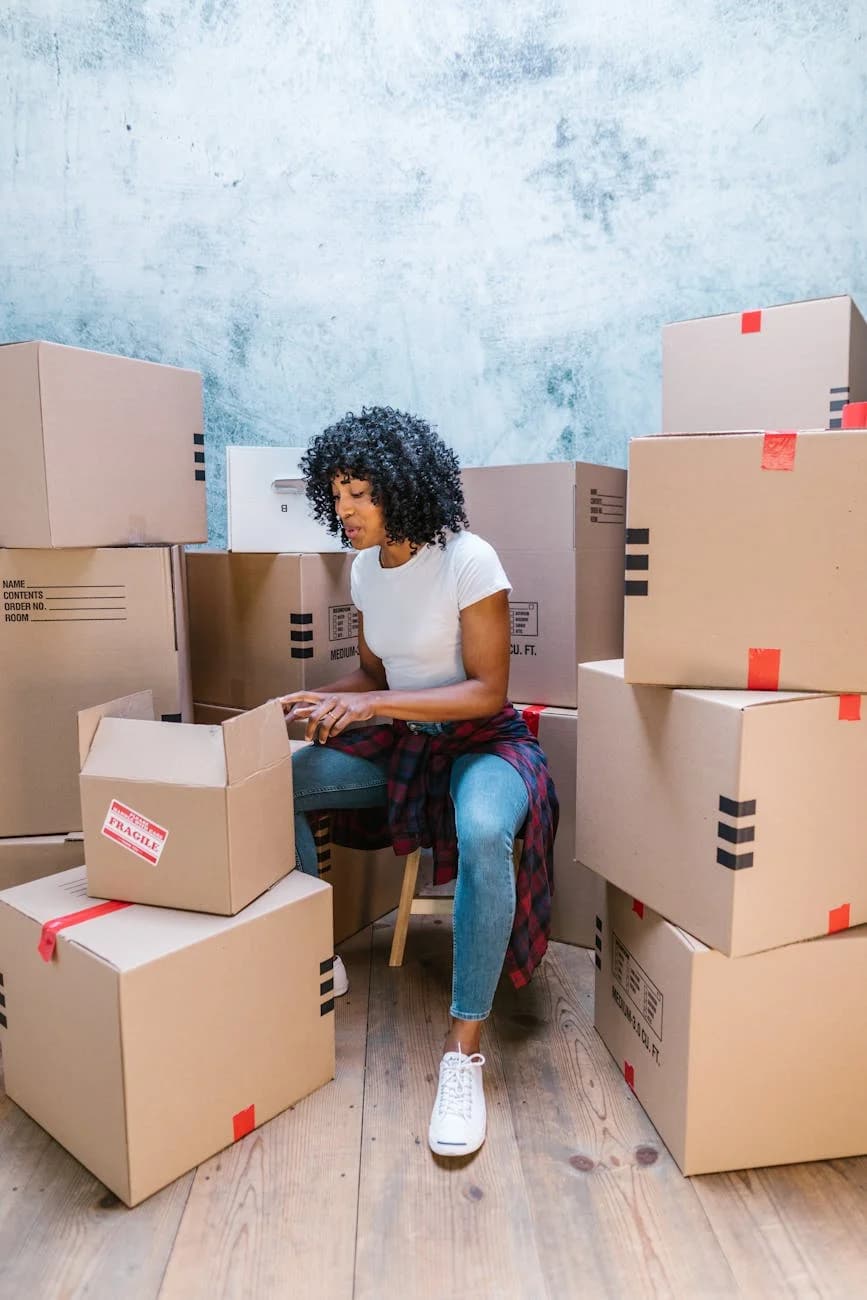 A Woman Organizing Cardboard Boxes In A 3